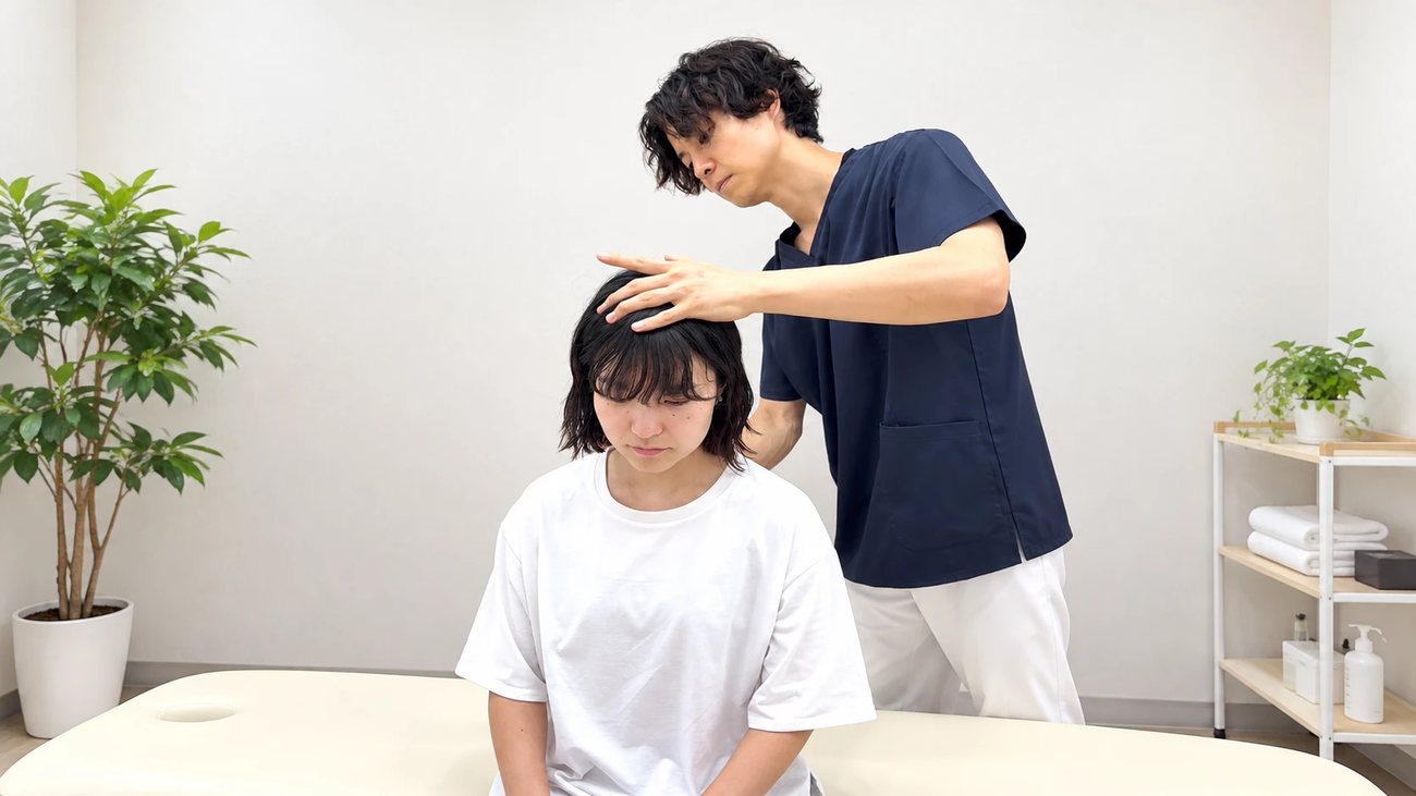 頭にやさしく手を当てる施術